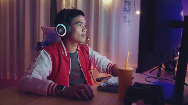 Side view of Male gamer using a headset and having fun with an online video game.