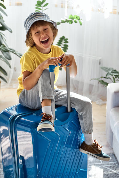 istock A child sitting on a suitcase have fun and laughs, waiting for a trip on vacation 1461125068