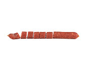 Sliced thin half-smoked sausage on a white background.