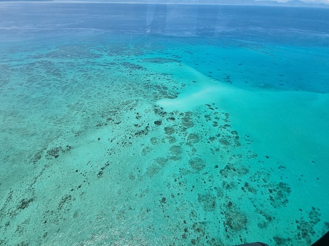Aerial capture of coral san cay and Great Barrier Reef with clear blue water, Queensland, Australia