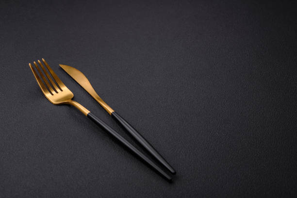 istock Metal kitchen knife and fork on a dark textured concrete background 1461132314