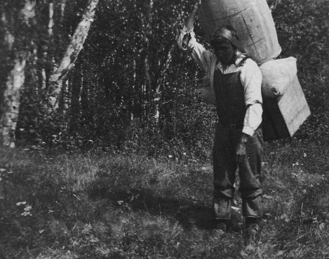 Saskatchewan, Canada - 1919. Porter in an expedition group carrying 300lbs of equipment through the wilderness in Saskatchewan, Canada. File source is film.  Ca. 1919