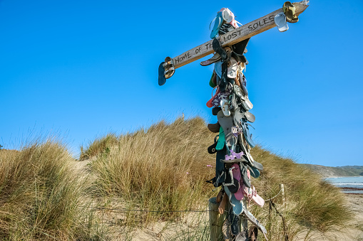 Castle Point New Zealand - October 5 2010: Collection lost footwear attached to cross on beach, Home of Lost Soles.