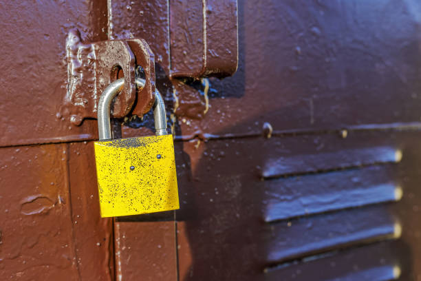 istock Metal door locked with a yellow padlock 1461136104