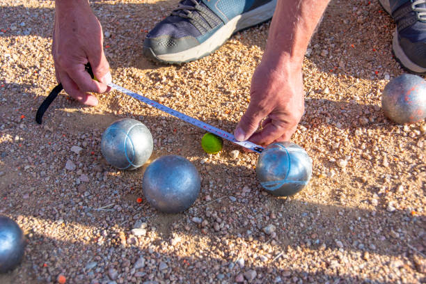 measuring with a measuring tape in the game of petanque (boule) - checking the time imagens e fotografias de stock