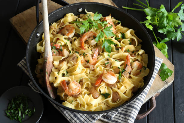 Tagliatelle pasta with shrimp and mushrooms. stock photo