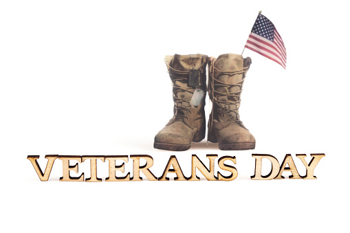 ,,Veteran's Day''  and old military combat boots with a small American flag
