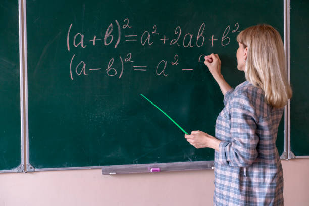 学校に戻る。教授は黒板で問題を解決します - professor teacher female blackboard ストックフォトと画像