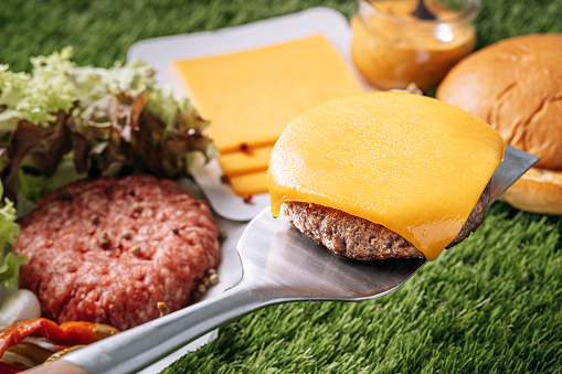 barbecue burger cutlet. barbeque concept in nature. barbecue spatula with a burger patty on it