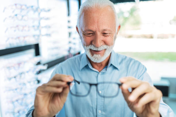 istock Senior man looking at different eyeglasses to buy 1461145645