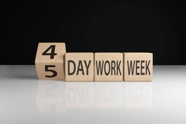Wooden blocks showing the term 4-day work week. Illustration of the concept of the trend and widespread of 4 working days per week