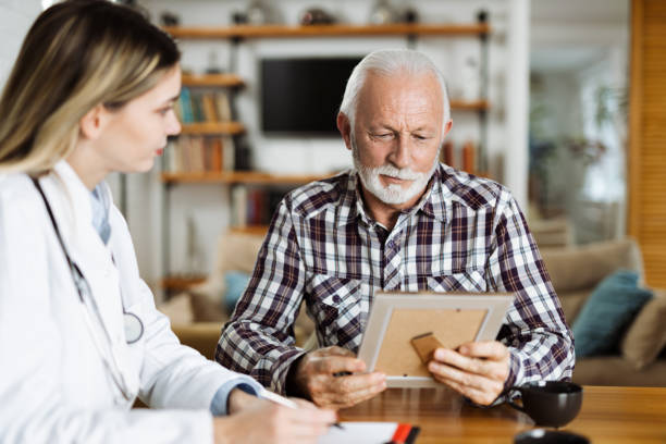 istock Mature man and his caregiver talking at  home 1461149202