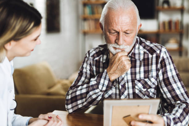 istock Mature man and his caregiver talking at  home 1461149730