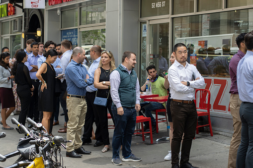 New York, NY, USA - July 6, 2022: Office workers line up outside a restaurant in Midtown Manhattan, New York City, during lunch time.