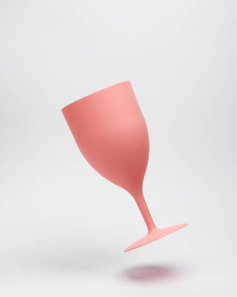 Pink plastic wine glass levitating on white background stock photo