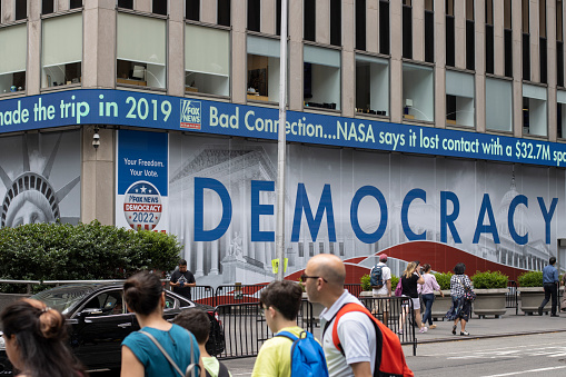 New York, NY, USA - July 6, 2022: Democracy sign is seen outside the News Corp Building, which houses the main Fox News studios, during the Fox News Channel's coverage of the 2022 midterm elections.