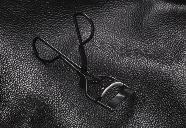 istock eyelash curler on black leather background 1461158299
