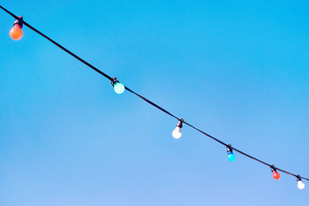 Christmas garland light bulbs on blue sky background