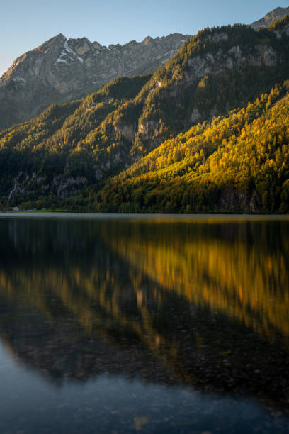 озеро осенью, отражающее горы и ливхт солнца - lake alaska mountain mountain range стоковые фото и изображения