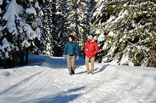 A young couple hiking on a mountain trail in winter.