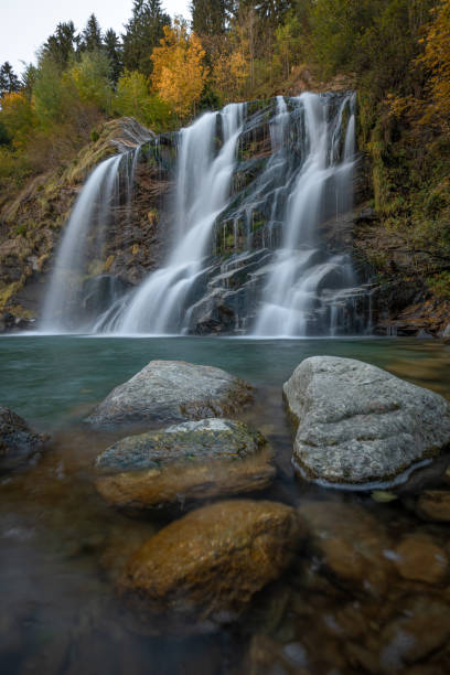 istock A waterfall in autumn with stones in the foreground 1461166915