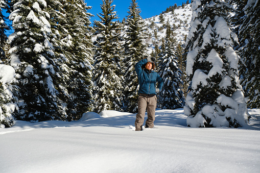 A woman snowshoeing in the Utah USA mountains.