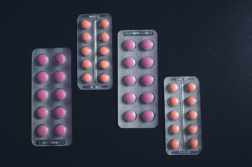 Pills in blister packs over black background