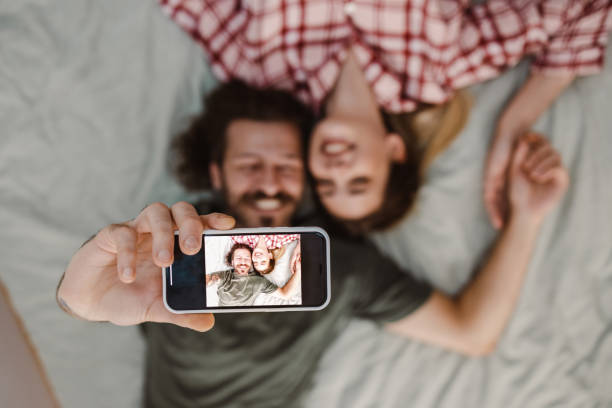 istock Young couple taking selfie in bed 1461170053