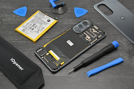 A disassembled Motorola smart phone in the process of a battery repair. Motorola partners with iFixit to provide users with genuine parts, tools, and guides to repair their own devices. A kit like this uses precision screwdrivers and a variety of opening and prying tools to safely do a repair at home.
