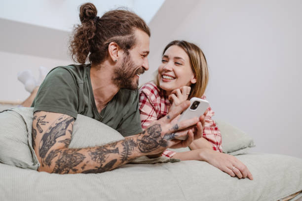 istock Lovely couple using smart phone in bed 1461170563