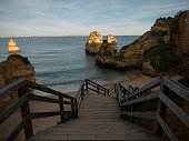 Panorama view of wooden walkway stairs staircase stairway leading down to Praia do Camilo beach Lagos Algarve Portugal