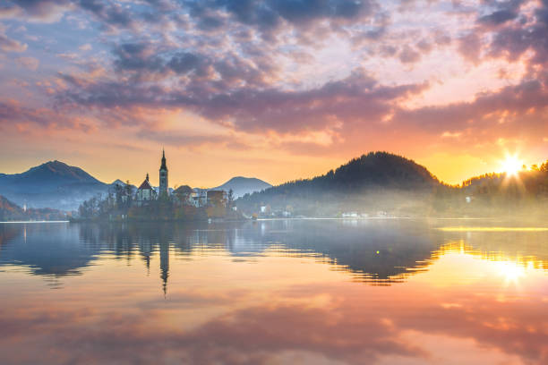 lago bled no nascer do sol, slovenia - santa maria church - fotografias e filmes do acervo