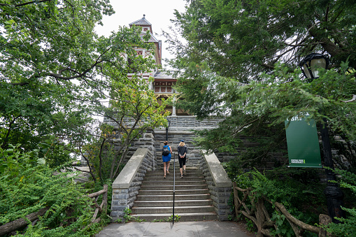 New York, NY, USA - July 6, 2022: Visitors to the Belvedere Castle, a miniature castle located atop Vista Rock in New York City's Central Park, on a summer day.