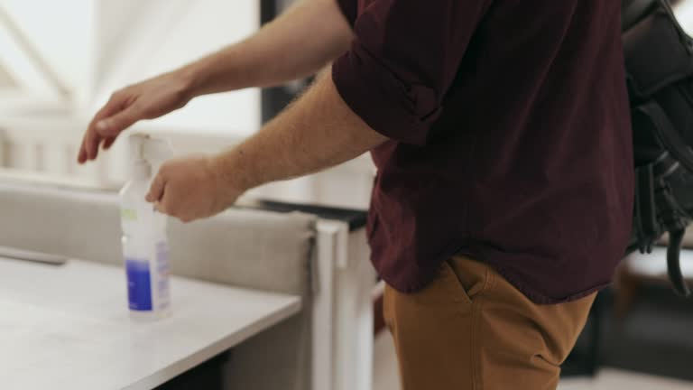 Employee arriving at work and putting on hand sanitizer