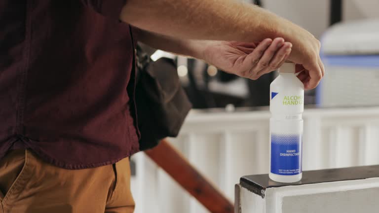 Employee putting on hand sanitizer at his office entrance