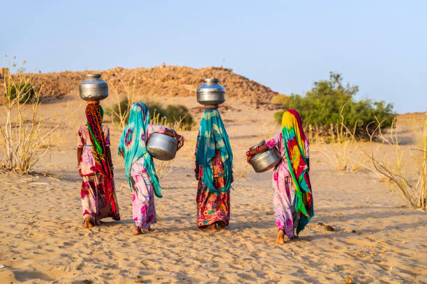 jeunes filles indiennes transportant de l’eau d’un puits, village du désert, inde - porter sur la tête photos et images de collection