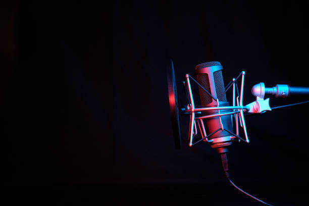 istock a black microphone on black background under the neon light. podcasting, singing, and recording background. 1461181685