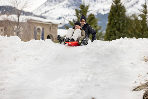 High quality stock photos of a family sledding in their residential neighborhood