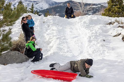 High quality stock photos of a family sledding in their residential neighborhood