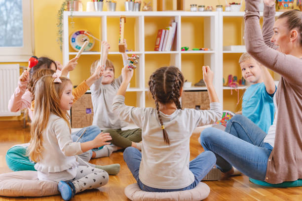 istock Teacher with children in a Kindergarten Classroom. Healthy learning environment. Kindergarten teacher, building relationships with the kids. Cheerful preschool children 1461187748