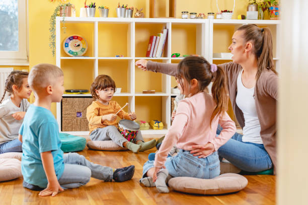 istock Teacher with children in a Kindergarten Classroom. Healthy learning environment. Kindergarten teacher, building relationships with the kids. Cheerful preschool children 1461187827