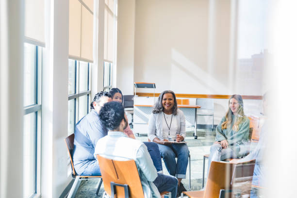 istock Members of therapy group smile as young man shares 1461189370