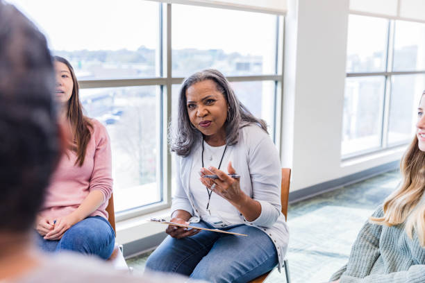 istock Senior female counselor asks unrecognizable man questions 1461189378