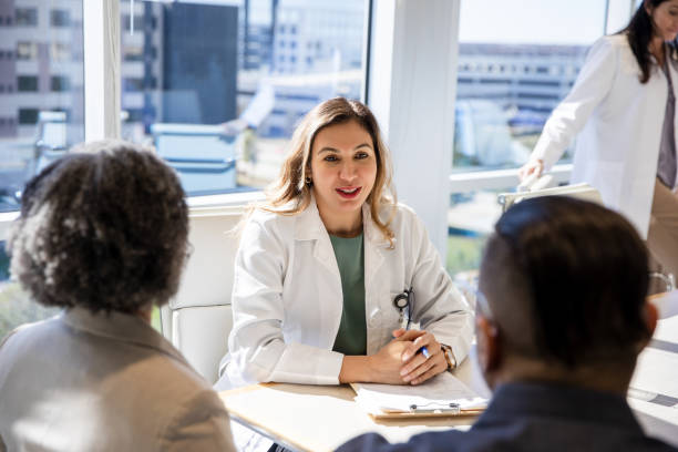 istock Female doctor talks with couple 1461189948
