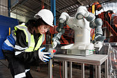 Female engineer control robot in factory