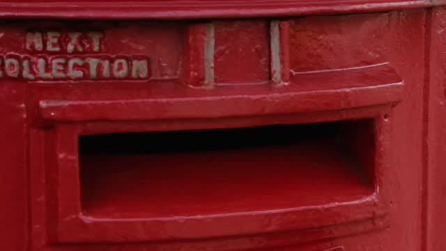 Hand of a Young Man sending Mail, Posting a Letter Into a Post Box, UK. Close Up.