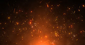 Abstract orange fiery sparks and smoke from a bonfire with fire, abstract background