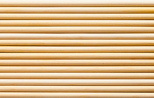Pile of Thin Wood Pole Dowels Background