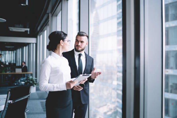 istock Colleagues talking near office windows 1461198259