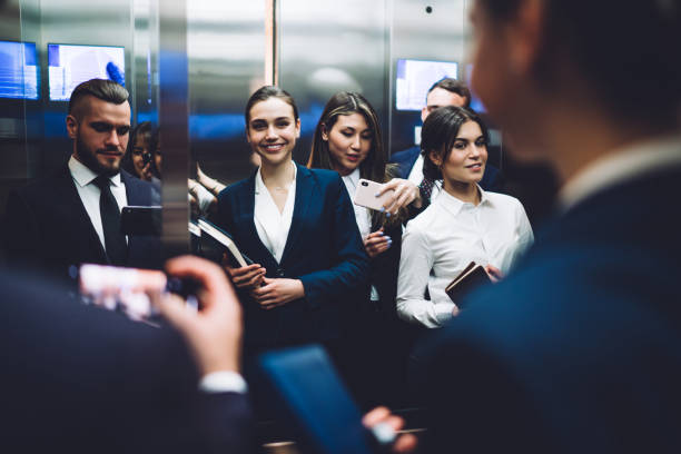 istock Happy coworkers taking selfie while standing in elevator together 1461198661